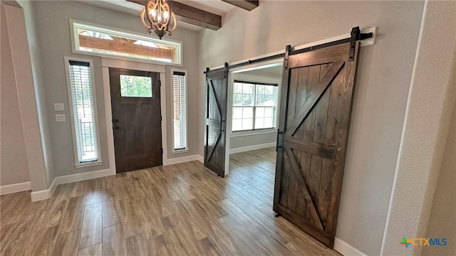 1026 County Road 3152, Kempner, TX 76539 - foyer featuring a barn door, light wood finished floors, baseboards, beamed ceiling, and a chandelier