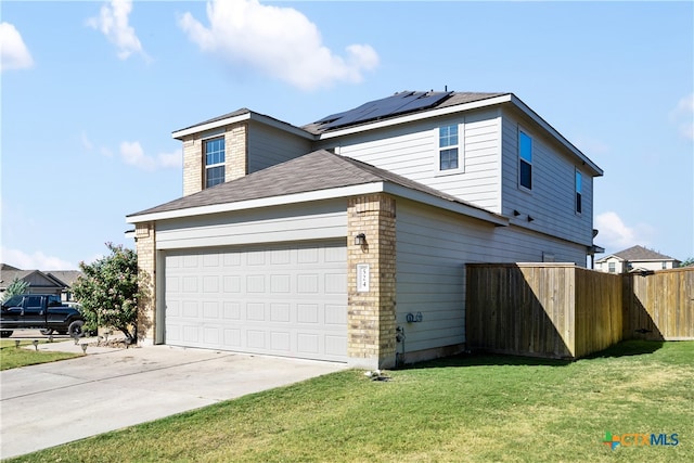 view of side of property featuring a garage, solar panels, and a yard