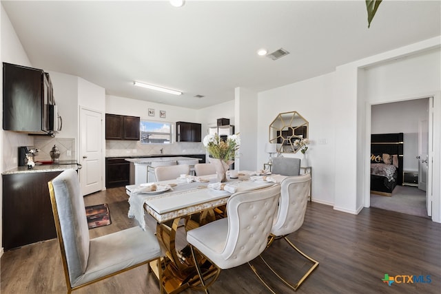 dining room featuring dark wood-type flooring and sink