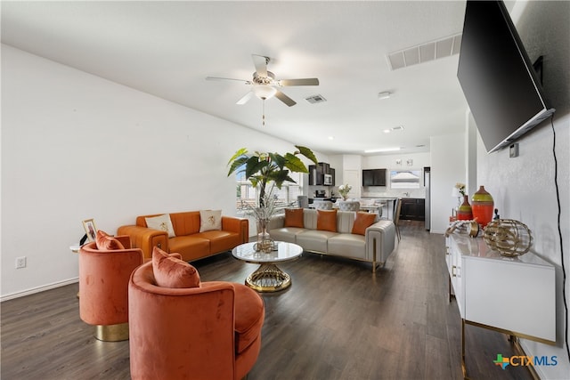 living room featuring ceiling fan and dark hardwood / wood-style floors