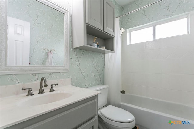 full bathroom featuring tiled shower / bath combo, toilet, and vanity