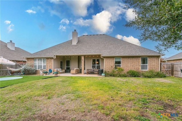 back of house with a patio area and a yard