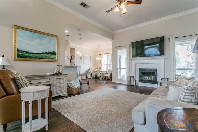 living room with ceiling fan, dark hardwood / wood-style flooring, crown molding, and a wealth of natural light