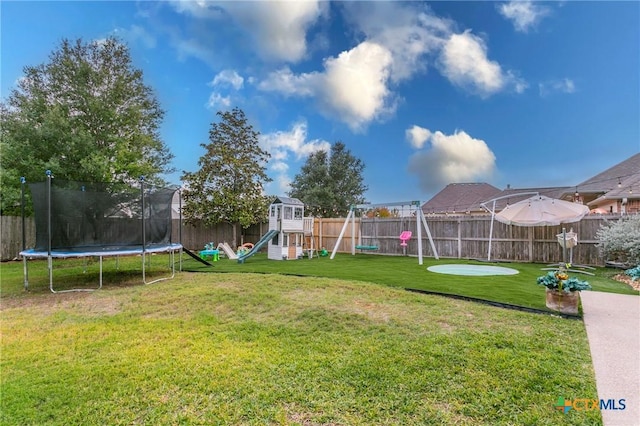 view of yard with a playground and a trampoline