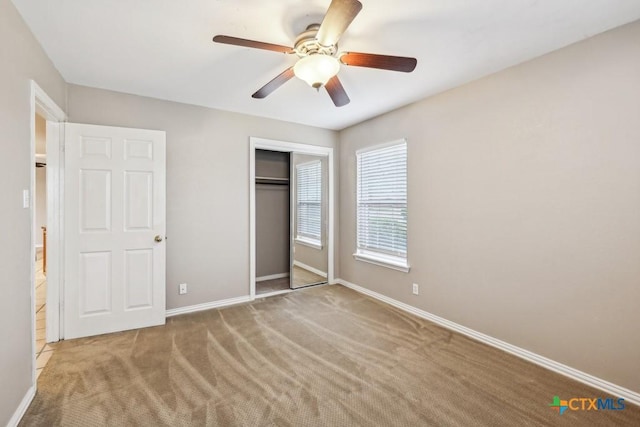 unfurnished bedroom with a closet, ceiling fan, and light carpet