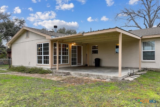 back of property with a patio area and a lawn