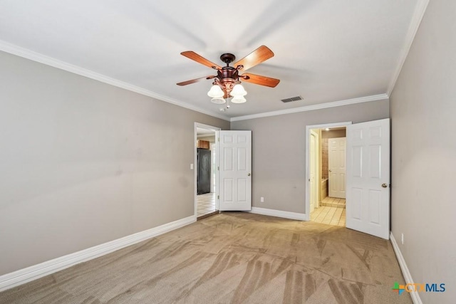 unfurnished bedroom with ceiling fan, ensuite bathroom, light carpet, and ornamental molding