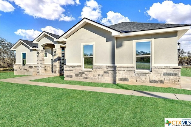 105 Hondo Rdg, La Vernia, TX 78121 - ranch-style home with a front lawn, stone siding, stucco siding, and roof with shingles