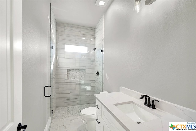 bathroom featuring a shower with shower door, vanity, and toilet