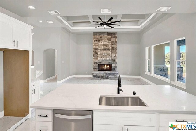 105 Hondo Rdg, La Vernia, TX 78121 - kitchen with stainless steel dishwasher, a sink, coffered ceiling, open floor plan, and white cabinets