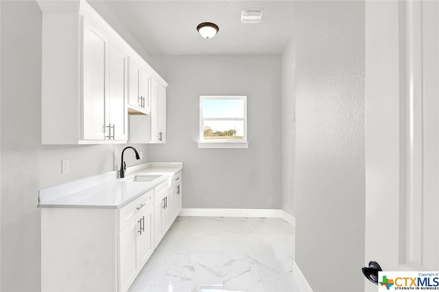 interior space featuring white cabinets and sink