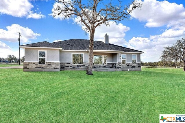 105 Hondo Rdg, La Vernia, TX 78121 - rear view of house featuring stucco siding, stone siding, and a lawn