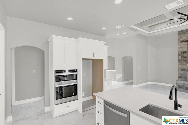 105 Hondo Rdg, La Vernia, TX 78121 - kitchen featuring arched walkways, a sink, appliances with stainless steel finishes, light marble finish floors, and recessed lighting