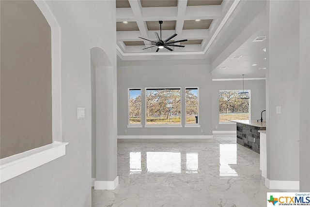 hall featuring coffered ceiling, a chandelier, crown molding, and beamed ceiling