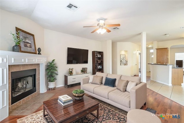 404 Chieftain Trl, Harker Heights, TX 76548 - living room with a tiled fireplace, a ceiling fan, light wood-style flooring, and visible vents