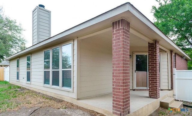 404 Chieftain Trl, Harker Heights, TX 76548 - view of side of home featuring brick siding, fence, and a chimney