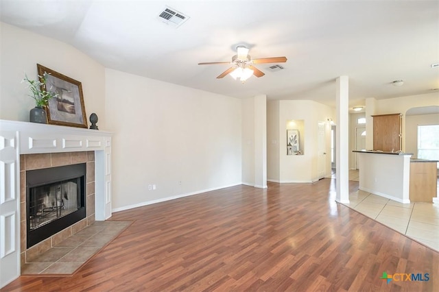 404 Chieftain Trl, Harker Heights, TX 76548 - unfurnished living room with a ceiling fan, visible vents, a tiled fireplace, and light wood-style flooring