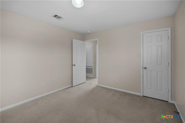 unfurnished bedroom with carpet flooring, baseboards, and visible vents