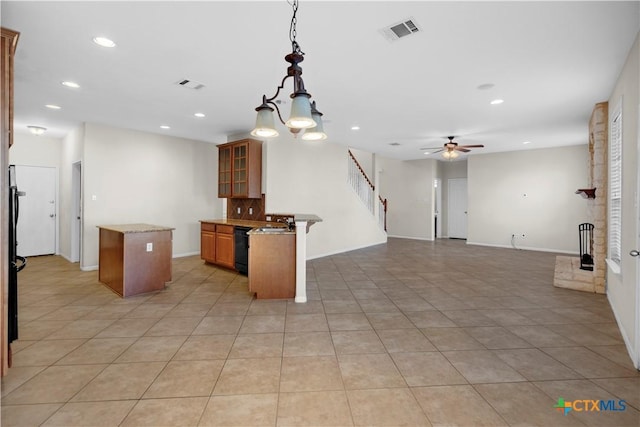 kitchen featuring visible vents, dishwasher, open floor plan, and a center island