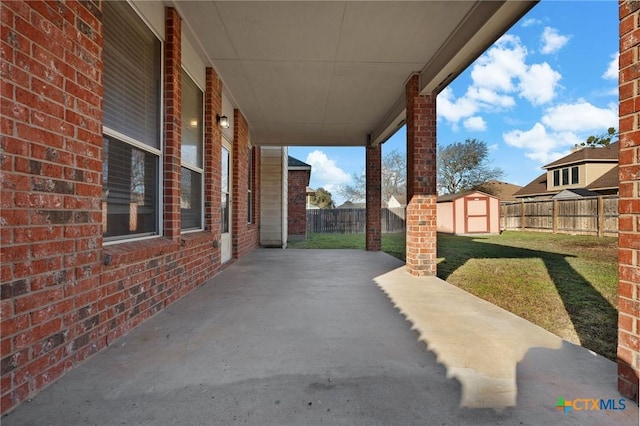 view of patio / terrace with a fenced backyard, a storage shed, and an outdoor structure