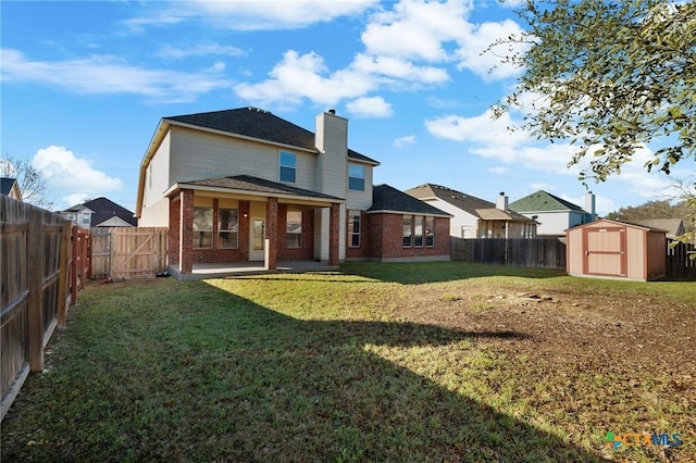 back of house featuring brick siding, a storage shed, and a fenced backyard