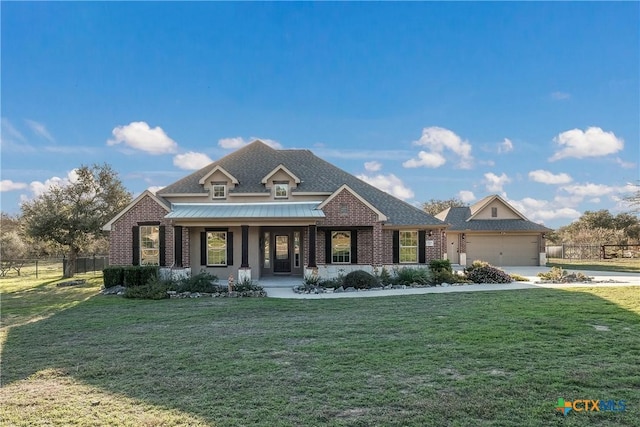 view of front facade with driveway, fence, a front lawn, and brick siding