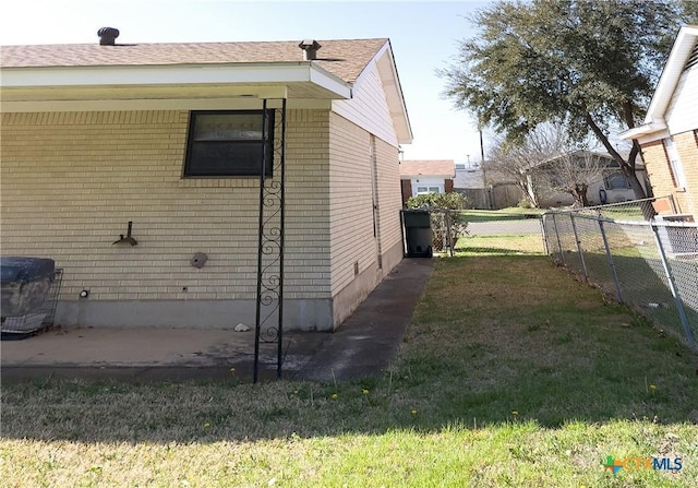 view of property exterior with a lawn, brick siding, and fence