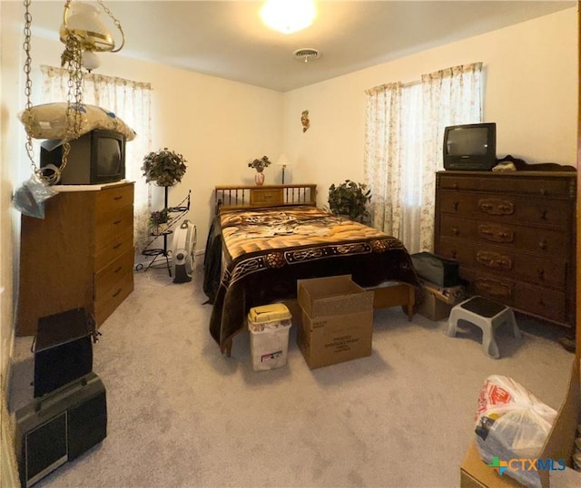 bedroom with visible vents and carpet