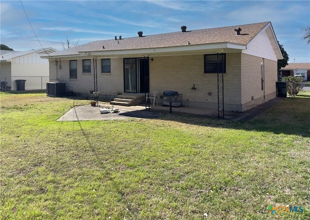 rear view of property with cooling unit, fence, entry steps, a patio area, and a lawn