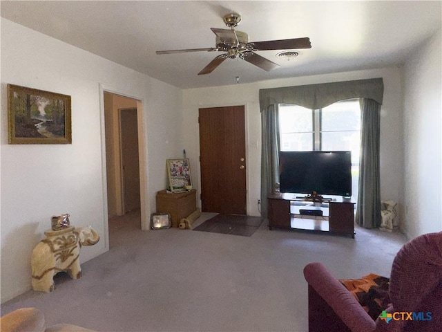 carpeted living area with visible vents and ceiling fan