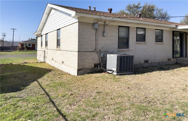 back of property with crawl space, central air condition unit, a yard, and fence