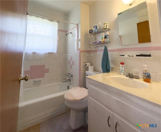 full bath featuring a wainscoted wall, toilet, tile walls, shower / bath combination, and vanity