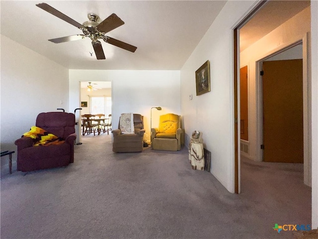 living area featuring visible vents, carpet, and ceiling fan