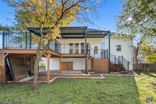 rear view of house with a lawn, a deck, and a patio