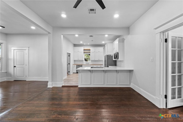 kitchen with white cabinets, dark hardwood / wood-style floors, ceiling fan, kitchen peninsula, and stainless steel appliances