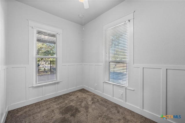 carpeted spare room featuring ceiling fan and a healthy amount of sunlight