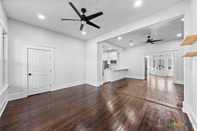 unfurnished living room featuring dark hardwood / wood-style floors and ceiling fan