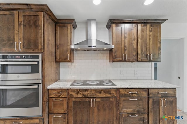 6022 Wildwind Dr, Windcrest, TX 78239 - kitchen featuring wall chimney range hood, black electric stovetop, double oven, backsplash, and dark brown cabinetry