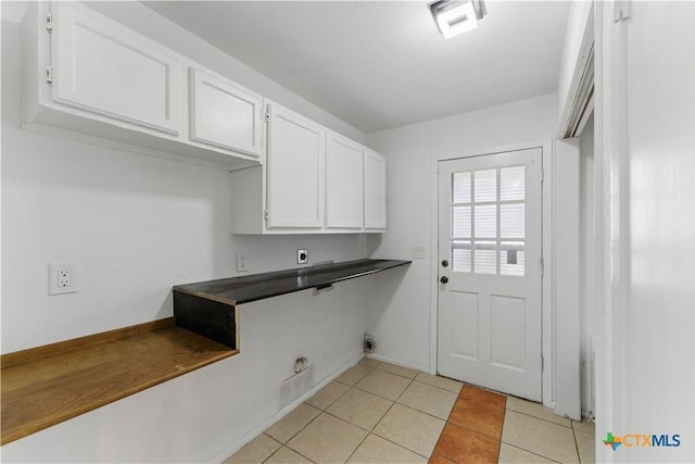 6022 Wildwind Dr, Windcrest, TX 78239 - clothes washing area with electric dryer hookup, cabinet space, and light tile patterned floors