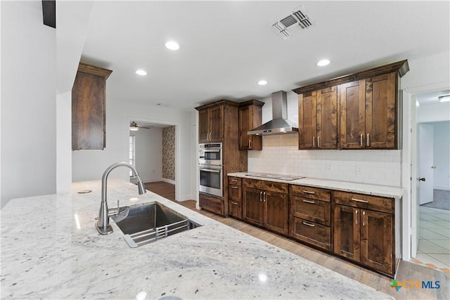 6022 Wildwind Dr, Windcrest, TX 78239 - kitchen featuring wall chimney exhaust hood, a sink, double oven, light stone counters, and recessed lighting