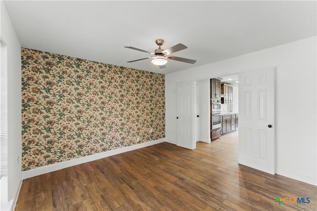 6022 Wildwind Dr, Windcrest, TX 78239 - spare room with wallpapered walls, baseboards, ceiling fan, and wood finished floors