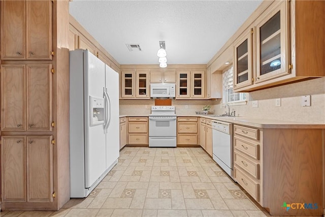 kitchen featuring sink, white appliances, a textured ceiling, light brown cabinetry, and decorative backsplash