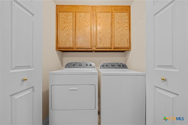 washroom featuring cabinets and washer and dryer