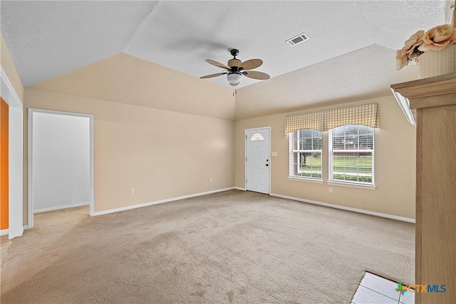 unfurnished living room featuring ceiling fan, light colored carpet, vaulted ceiling, and a textured ceiling