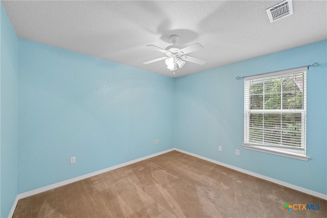 carpeted spare room featuring ceiling fan and a textured ceiling