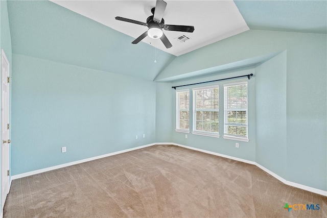 spare room with ceiling fan, vaulted ceiling, and carpet