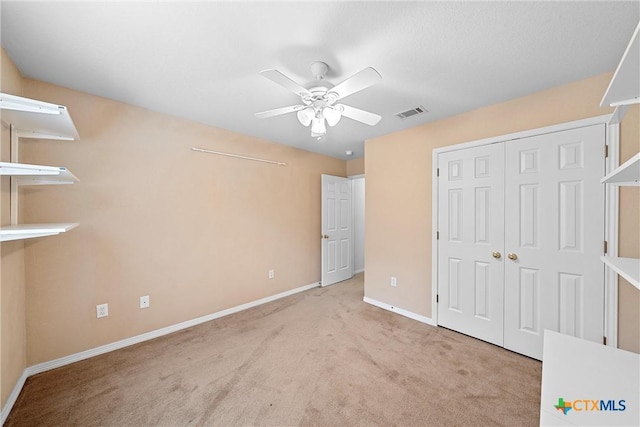 unfurnished bedroom with light carpet, a closet, and ceiling fan