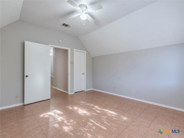 additional living space featuring a textured ceiling, ceiling fan, lofted ceiling, and light tile patterned flooring