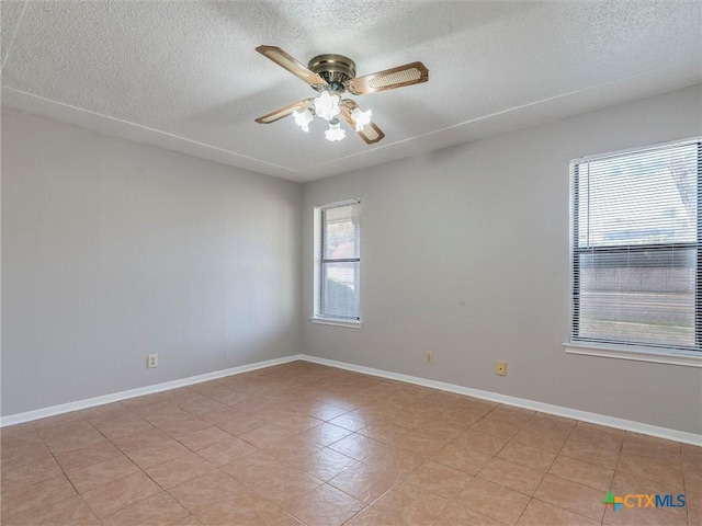 empty room with ceiling fan and a textured ceiling