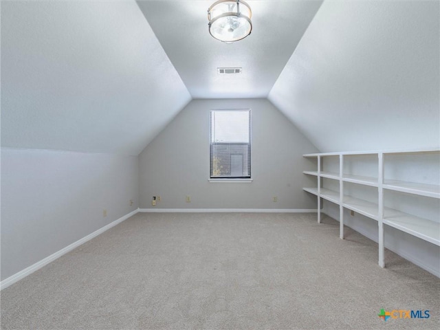 bonus room with light colored carpet and lofted ceiling